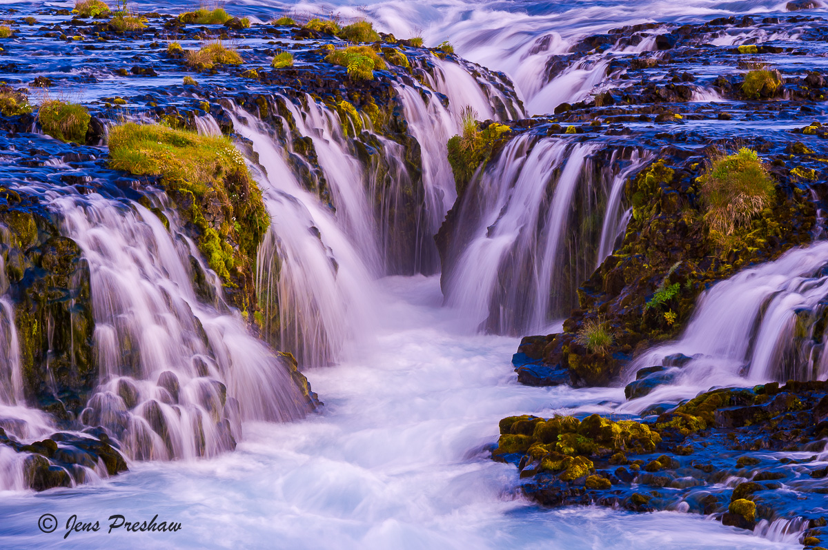 This is one of the most beautiful waterfalls I photographed in all of Iceland. It's a small waterfall with brilliant blue glacial...