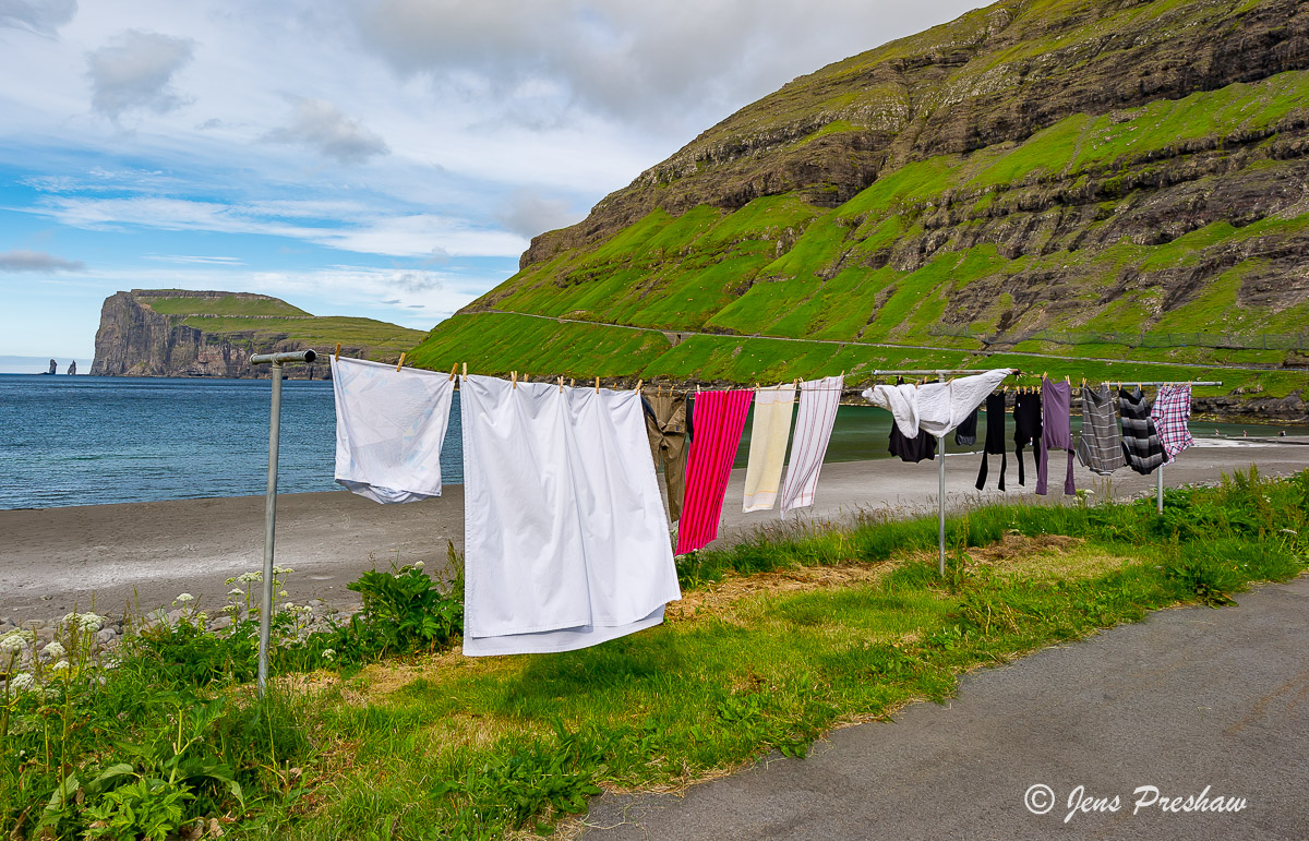 In the village of Tjornuvik clothes dry on a summer day. The sea stacks&nbsp;Risin&nbsp;and&nbsp;Kellingin&nbsp;are visible in...