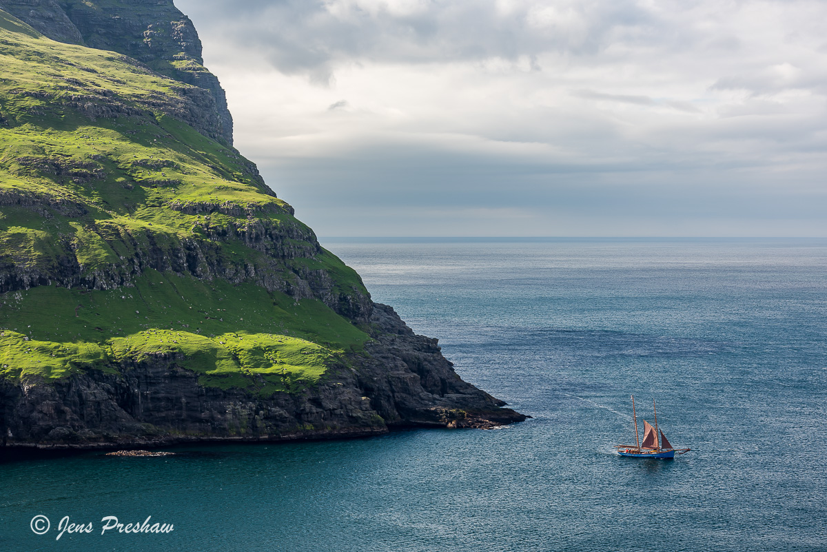 A wooden sailing ship sails towards Sundini.